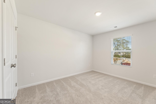 spare room featuring light carpet, baseboards, and recessed lighting