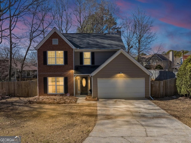 traditional-style house with a garage, concrete driveway, brick siding, and fence