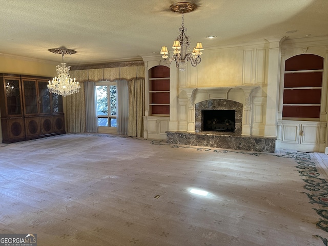 unfurnished living room featuring a chandelier, crown molding, a textured ceiling, and built in shelves