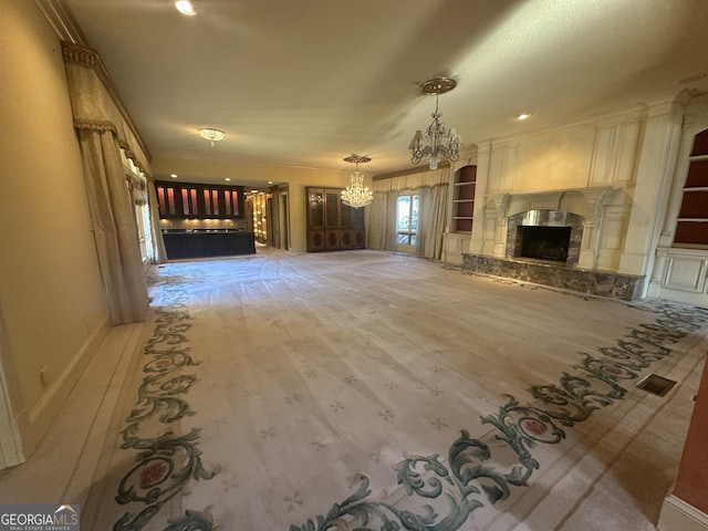 unfurnished living room featuring built in features, wood finished floors, a chandelier, and a premium fireplace