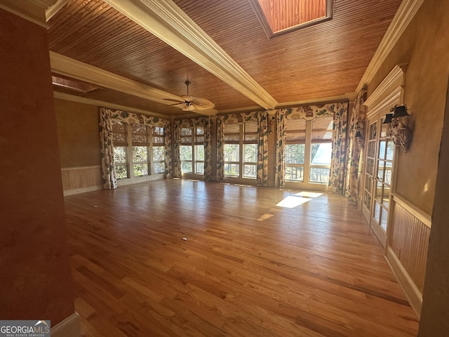 interior space with wooden ceiling, crown molding, a wainscoted wall, and wood finished floors