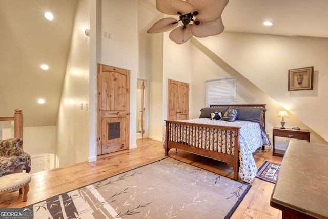 bedroom with a towering ceiling, a ceiling fan, wood finished floors, and recessed lighting