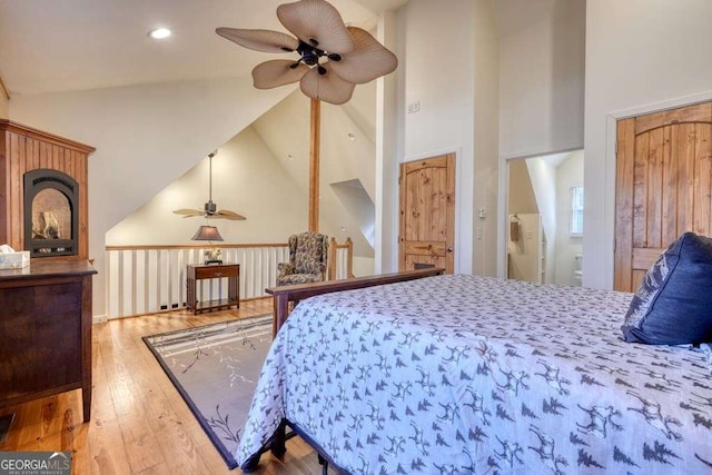 bedroom featuring high vaulted ceiling, hardwood / wood-style flooring, and recessed lighting