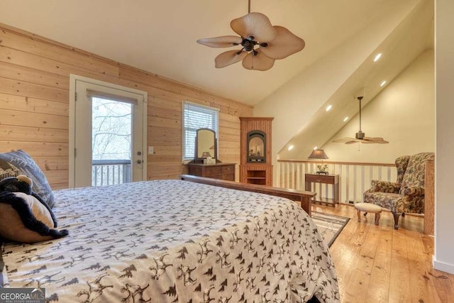 bedroom featuring vaulted ceiling, access to outside, hardwood / wood-style floors, and wood walls