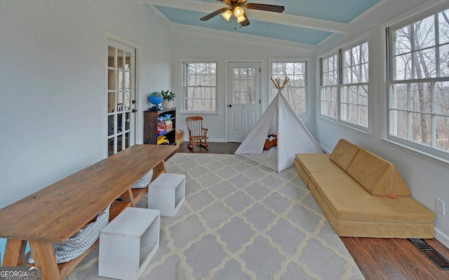 sunroom featuring vaulted ceiling with beams, visible vents, and a ceiling fan