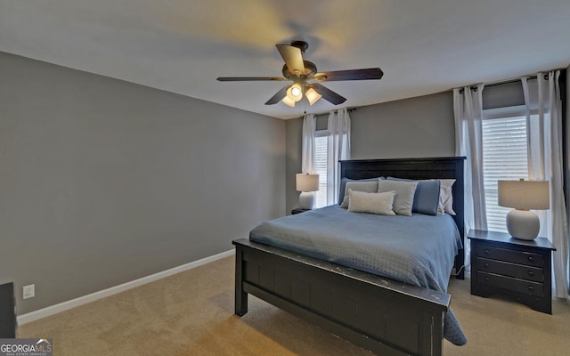 carpeted bedroom with a ceiling fan and baseboards