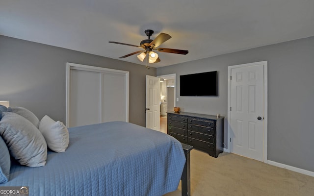 bedroom featuring ceiling fan, baseboards, a closet, and light colored carpet