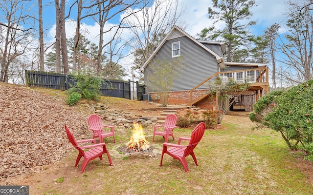 view of yard featuring stairway, fence, a fire pit, and a deck