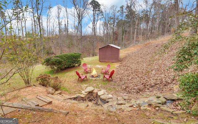 view of yard with a storage unit, an outdoor fire pit, and an outdoor structure