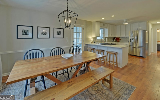 dining room with light wood finished floors, a notable chandelier, and recessed lighting