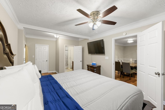 bedroom with a textured ceiling, ornamental molding, and wood finished floors