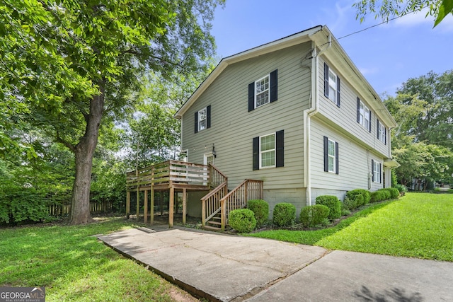 rear view of house featuring stairway, a deck, and a yard