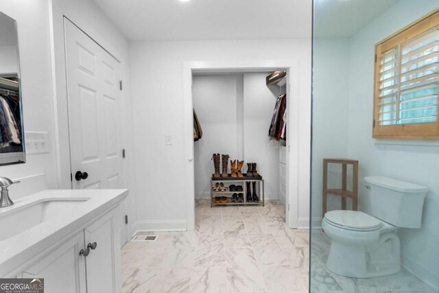 bathroom with marble finish floor, baseboards, vanity, and toilet