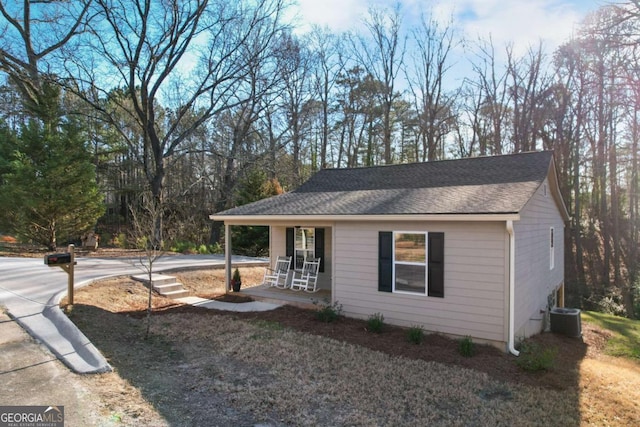 view of front of house featuring covered porch, central AC unit, and roof with shingles