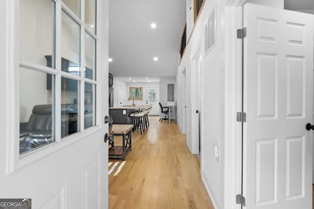 hallway with light wood-type flooring, visible vents, and recessed lighting