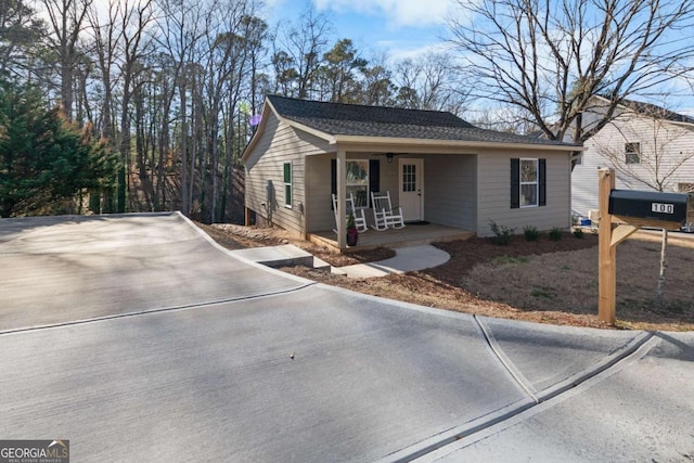 ranch-style home with covered porch and roof with shingles