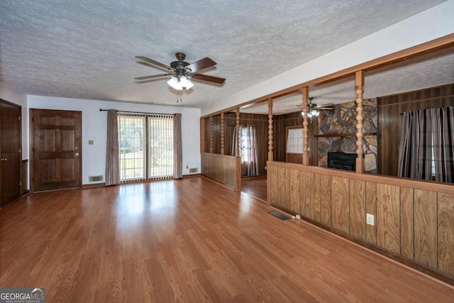 unfurnished living room featuring a textured ceiling, a ceiling fan, and wood finished floors