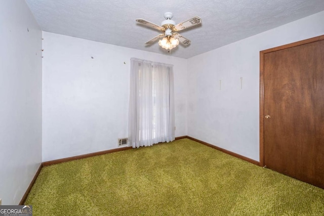 carpeted empty room featuring visible vents, ceiling fan, a textured ceiling, and baseboards