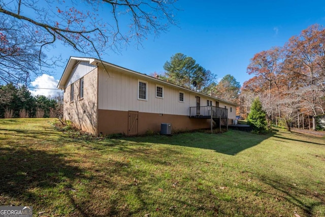 view of property exterior featuring central AC unit and a lawn