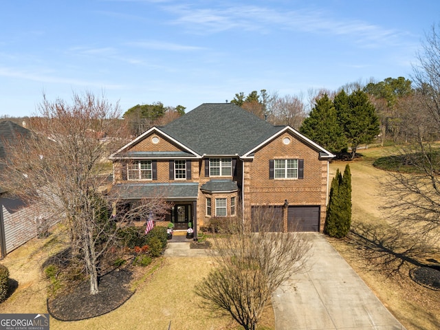 traditional-style house featuring driveway, an attached garage, and brick siding