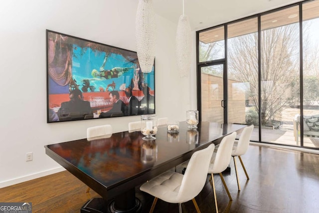 dining space with expansive windows, baseboards, and wood finished floors