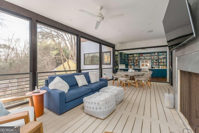 sunroom / solarium with a ceiling fan