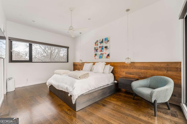 bedroom with ceiling fan, wood finished floors, and baseboards