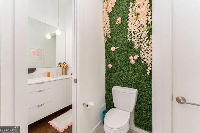 bathroom featuring wood finished floors, vanity, and toilet