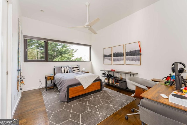 bedroom featuring ceiling fan, baseboards, and wood finished floors