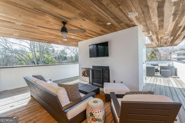 deck with an outdoor hangout area and a ceiling fan