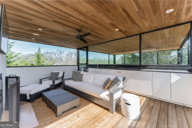 wooden terrace with ceiling fan and an outdoor living space