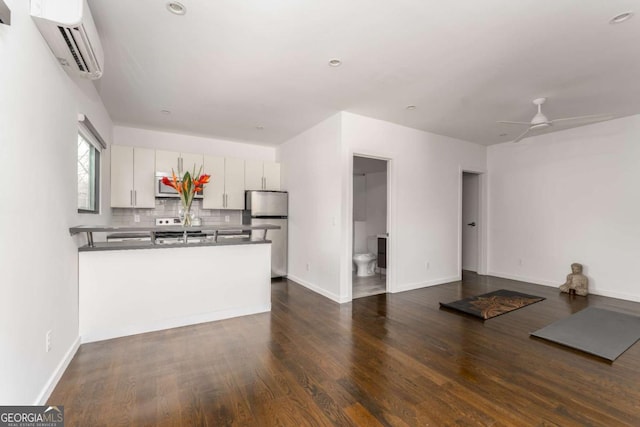 kitchen featuring a peninsula, white cabinets, stainless steel appliances, and open floor plan