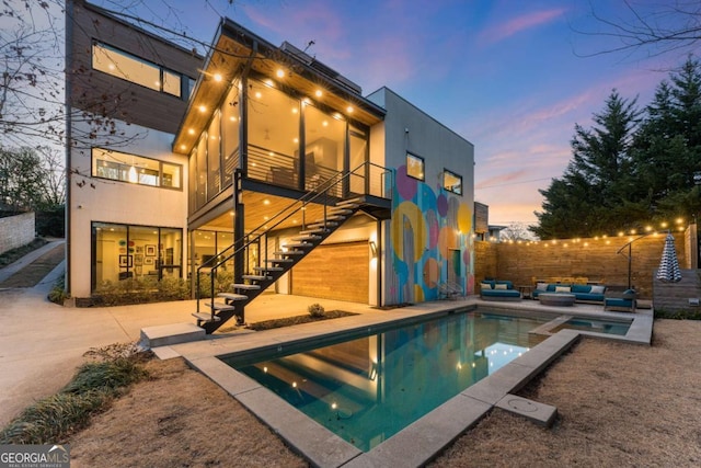 rear view of house featuring stairs, fence, a patio area, outdoor lounge area, and stucco siding