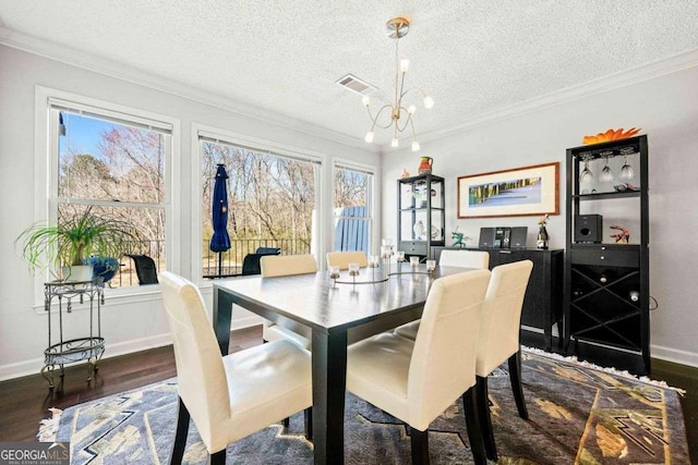 dining room with visible vents, a chandelier, wood finished floors, and ornamental molding