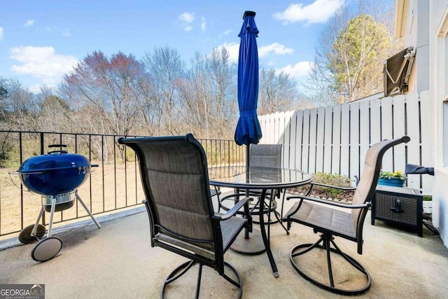 view of patio featuring outdoor dining space, a grill, and fence