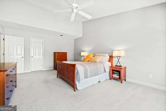 carpeted bedroom featuring lofted ceiling, ceiling fan, baseboards, and a textured ceiling