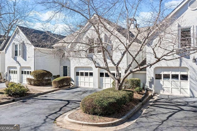 view of front of home with aphalt driveway, a garage, and stucco siding