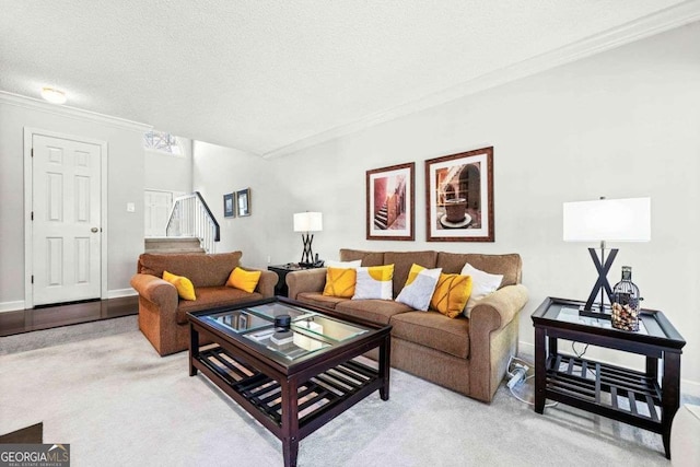 living room with a textured ceiling, ornamental molding, stairway, and light colored carpet