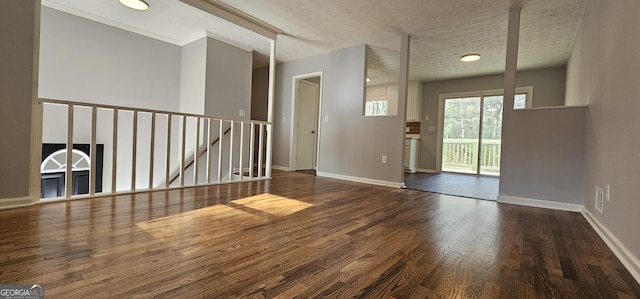 interior space featuring a textured ceiling, baseboards, and wood finished floors