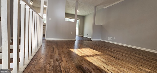 interior space with dark wood-style flooring, visible vents, and baseboards