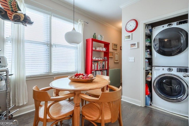 laundry area with dark wood-style floors, stacked washer and dryer, ornamental molding, laundry area, and baseboards