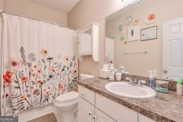 bathroom with curtained shower, vanity, toilet, and tile patterned floors