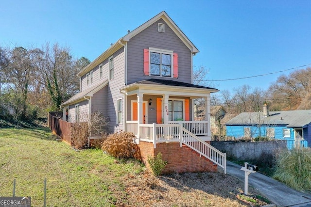 traditional home with covered porch and a front lawn