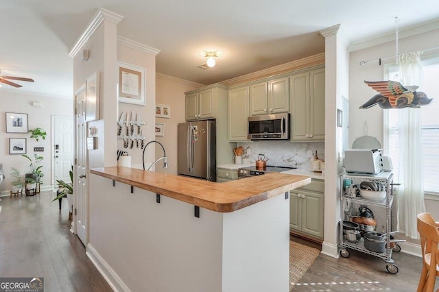 kitchen with ceiling fan, stainless steel appliances, ornamental molding, decorative backsplash, and dark wood-style floors