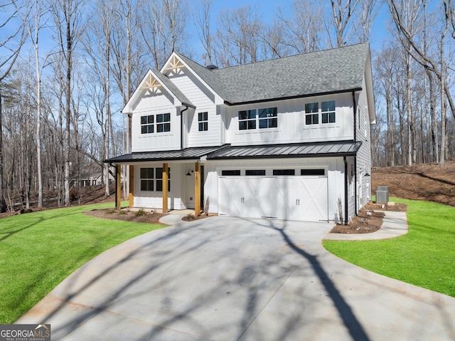 modern inspired farmhouse with an attached garage, concrete driveway, board and batten siding, a standing seam roof, and a front yard