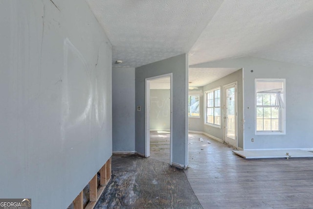 interior space featuring a textured ceiling, wood finished floors, and baseboards