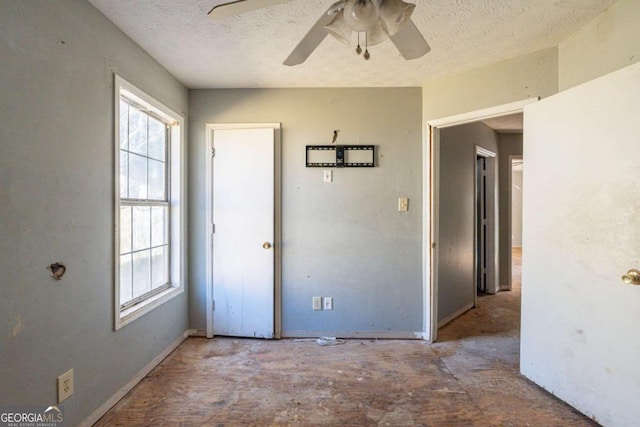 spare room with a textured ceiling, ceiling fan, and plenty of natural light