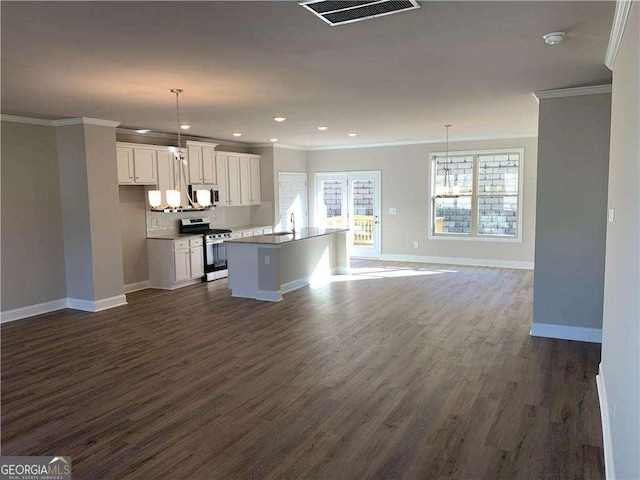 kitchen with ornamental molding, white microwave, stainless steel range, and visible vents