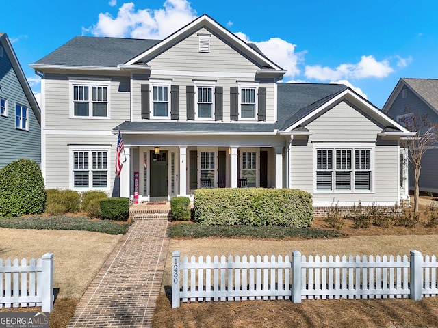 traditional-style home with a shingled roof, fence, and a porch