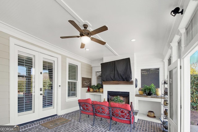 sunroom / solarium featuring ceiling fan, french doors, and an outdoor fireplace